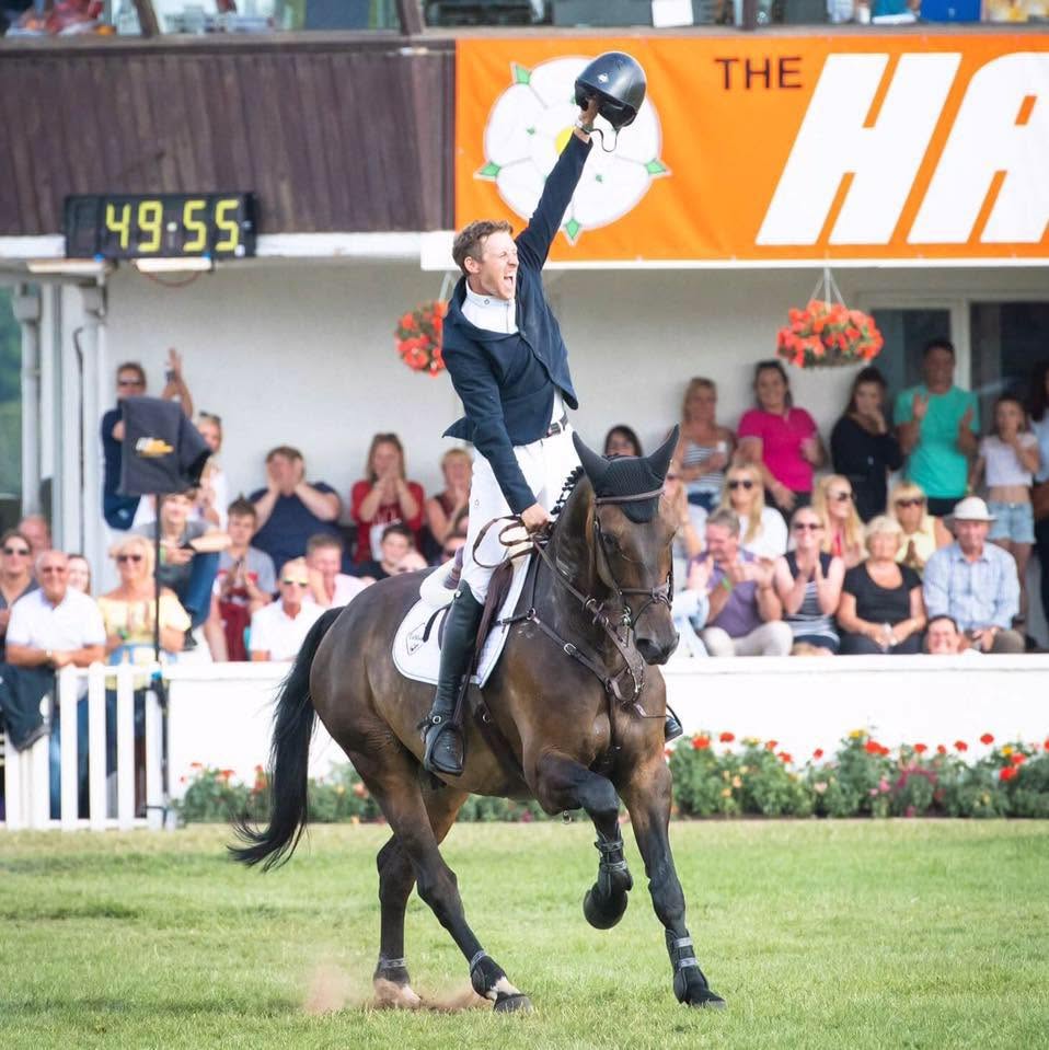 Joe Clayton, Olympic Show Jumper, celebrating on his bay horse